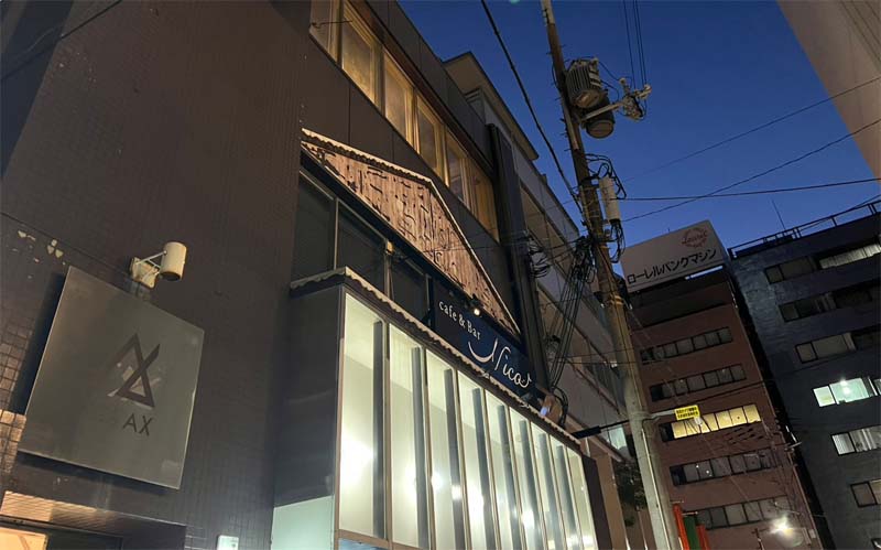 夜のミューズビル外観。2階にcafe & Bar Nicoの看板